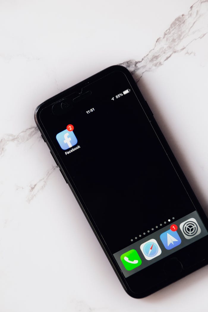 A smartphone displaying Facebook notifications lies on a marble surface, highlighting modern connectivity.